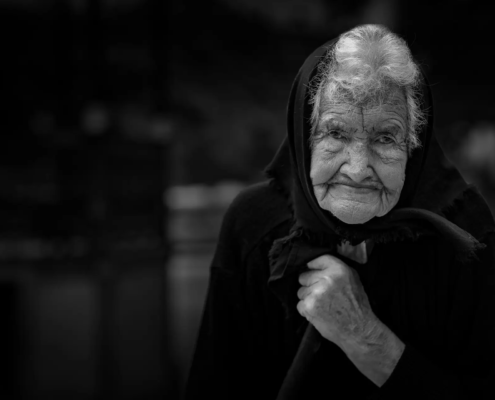 Oud vrouwtje op kerkhof, Portugal